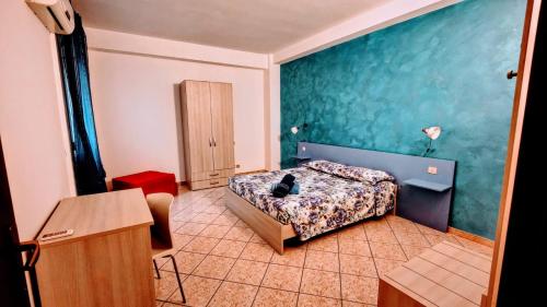 a bedroom with a bed and a table in a room at La Casa Del Viale in Solarino