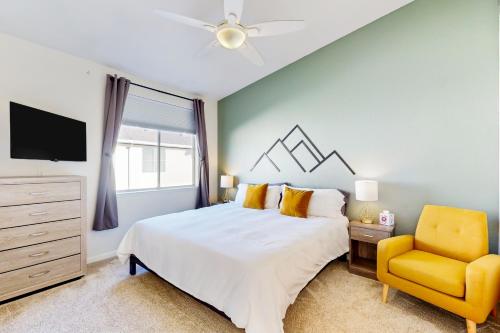 1 dormitorio con 1 cama y 1 silla amarilla en Mariners Cove 150, en Santa Cruz