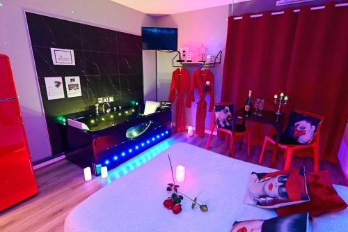 una camera con tavolo e una cucina con tende rosse di Grand Studio BISCARROSSE PLAGE Une nuit A 2 avec Sauna Luxe, Balnéo, Océan rien que pour vous a Biscarrosse