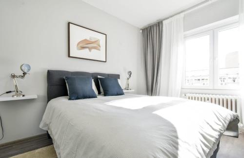 1 dormitorio blanco con 1 cama grande con almohadas azules en 1bd Presidential Neighbor Retreat, Ac, Kitchen, en Sofía