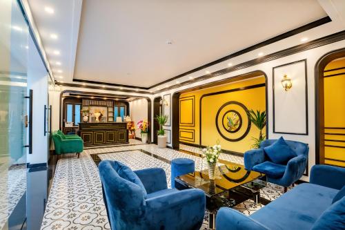 een woonkamer met blauwe stoelen en een tafel bij HA Royal Boutique Hotel in Hội An