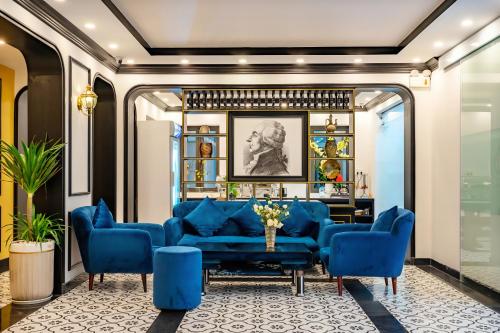 een woonkamer met blauwe banken en een tafel bij HA Royal Boutique Hotel in Hội An