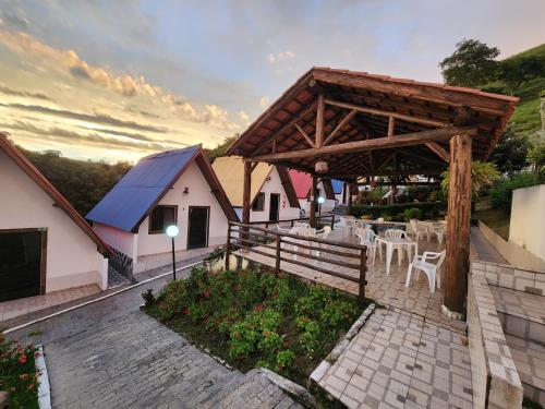 a pavilion with tables and chairs on a patio at Espaço Chalé Cereja in Cachoeira Paulista
