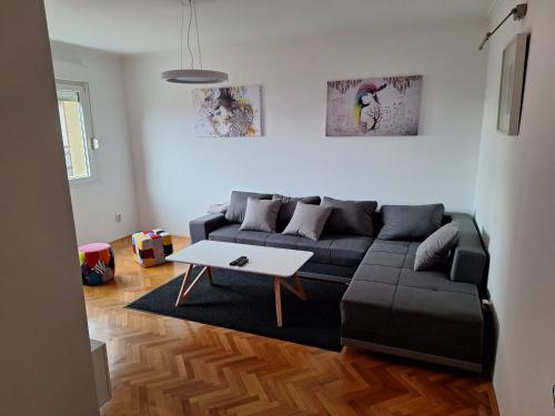 a living room with a black couch and a table at Temple saint sava in Dušanovac (historical)