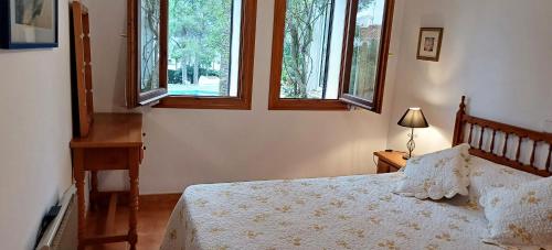 a bedroom with a bed and two windows at Bungalow Le Petit Chat in Pedreguer