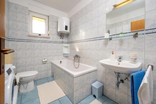 Baño blanco con lavabo y aseo en Apartment Anita, en Trogir