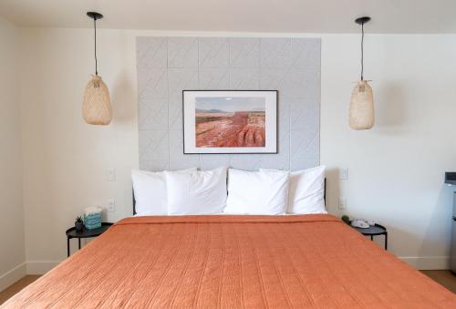a bedroom with a large orange bed with white pillows at Casitas at Capitol Reef in Torrey