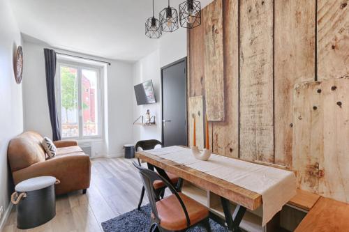 ein Wohnzimmer mit einem Tisch und einem Stuhl in der Unterkunft Magnifique appartement Porte d'Orléans in Montrouge