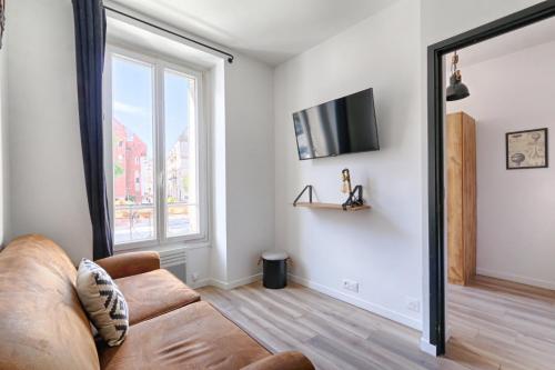 Una sala de estar con un sofá y una ventana. en Magnifique appartement Porte d'Orléans, en Montrouge