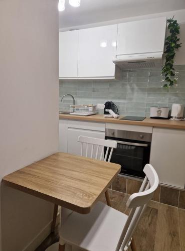 une cuisine avec une table en bois et des armoires blanches dans l'établissement Studio cosy près de la Croisette, à Cannes