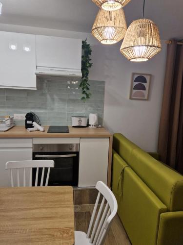 une cuisine avec une table et un canapé vert dans l'établissement Studio cosy près de la Croisette, à Cannes