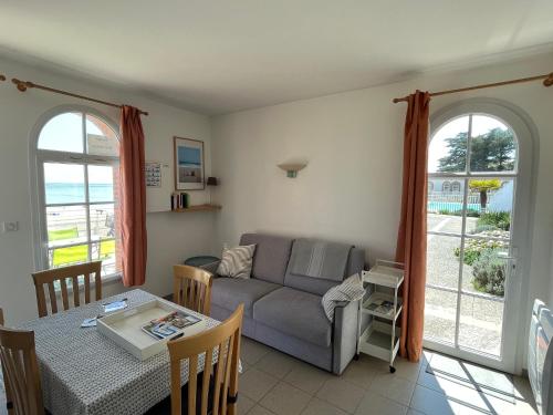 un salon avec un canapé et une table dans l'établissement Superbe appartement les pieds dans l'eau !, à La Tranche-sur-Mer