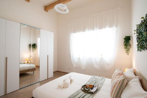 1 dormitorio con cama blanca y espejo en Isonzo House, en Bari