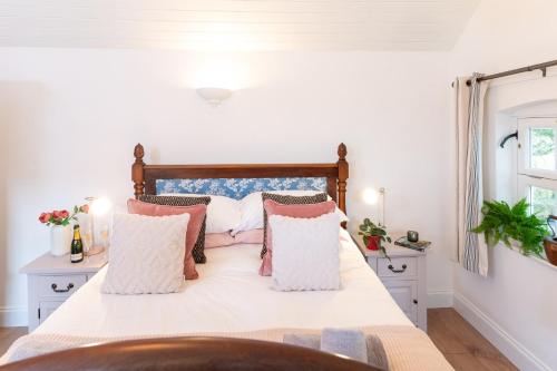 a bedroom with a large bed with pillows at Piglets Retreat in Budleigh Salterton