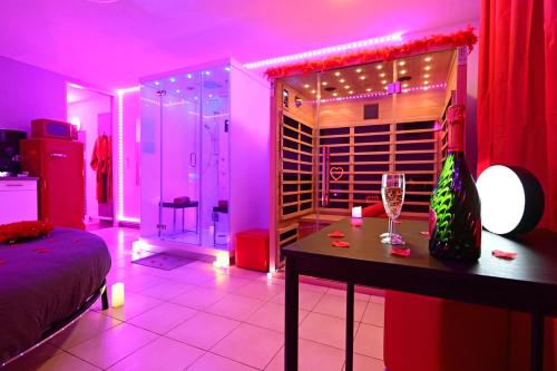 Cette chambre dispose d'une cave à vin avec une table et des verres à vin. dans l'établissement Love Room à deux pas de l'Océan avec Hammam, Sauna et Bain à 2 :-), à Biscarrosse