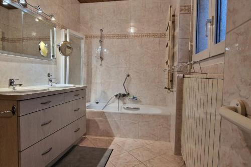 ein Badezimmer mit einer Badewanne, einem Waschbecken und einer Badewanne in der Unterkunft Charmant Appart. dans une Villa in Saint-Louis