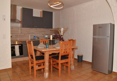 eine Küche mit einem Tisch und Stühlen sowie einem Kühlschrank in der Unterkunft Ferienwohnungen Hotel Bellevue in Seelisberg