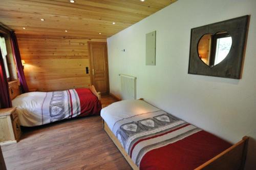 1 Schlafzimmer mit 2 Betten in einem Blockhaus in der Unterkunft L'ECHO DE LA CORNE in La Chapelle-dʼAbondance