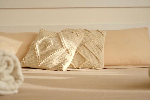 two pillows sitting on top of a bed at Darrere del port in Alghero