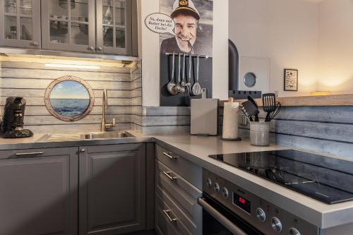 a kitchen with a sink and a picture of a man at 50002 Captains Loft in Carolinensiel