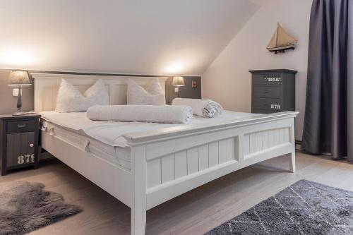 1 dormitorio con 1 cama blanca grande y almohadas blancas en 50002 Captains Loft, en Carolinensiel
