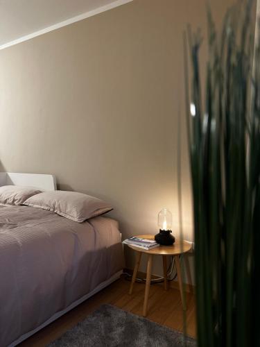Un dormitorio con una cama y una mesa con una vela. en Moderne Wohnung, zentral gelegen en Bielefeld