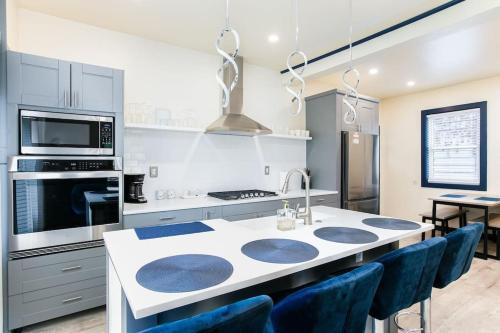 a kitchen with a white counter top and blue chairs at Walk to ND, Hot Tub, Lux Kitchen, Pet Friendly in South Bend