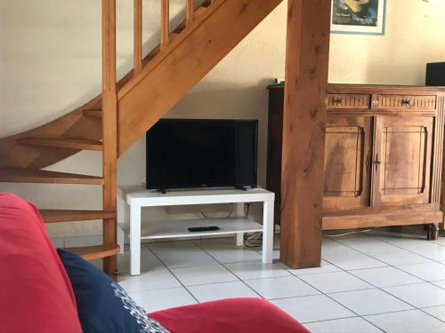 un salon avec une télévision sur une table blanche dans l'établissement Séjour tranquille à Oléron, à Grand-Village-Plage