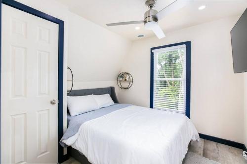 a white bedroom with a bed and a window at Walk to ND, Hot Tub, Lux Kitchen, Pet Friendly in South Bend