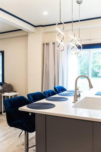 a kitchen with a sink and some blue chairs at Walk to ND, Hot Tub, Lux Kitchen, Pet Friendly in South Bend