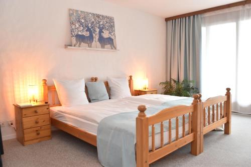 a bedroom with a wooden bed with white sheets and pillows at Ferienwohnungen Hotel Bellevue in Seelisberg