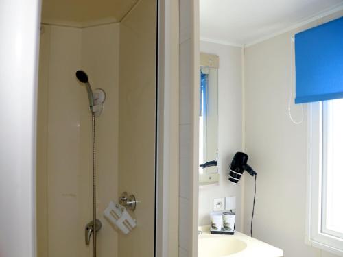 La salle de bains est pourvue d'un lavabo et d'une douche. dans l'établissement Sandilou lesPetitsBonheurs 2 Chambres Climatisé TV, à Sigean