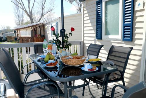 - une table sur une terrasse couverte avec de la nourriture dans l'établissement Sandilou lesPetitsBonheurs 2 Chambres Climatisé TV, à Sigean
