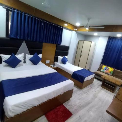 um quarto de hotel com duas camas e um sofá em HOTEL SHREE RADHE em Ahmedabad