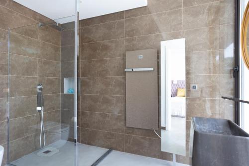 een badkamer met een douche en een glazen deur bij PV 62 in Castro Marim