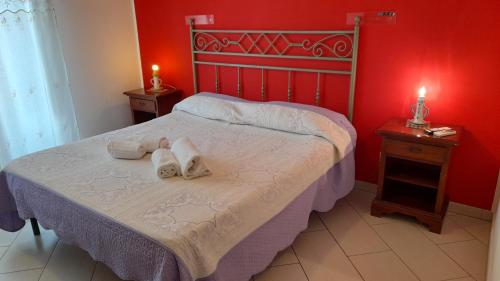 a bedroom with a bed with two towels on it at Pousada Noir in Trapani