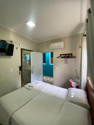 a bedroom with two beds and a door to a room at Residencial Águas de Bare in São Sebastião