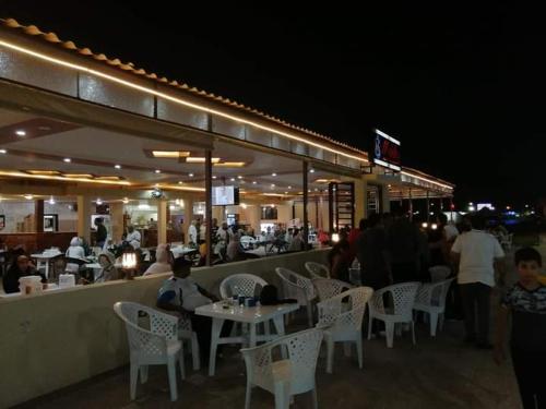 um restaurante com pessoas sentadas a mesas à noite em قرية النورس مكتب السعد em Ismaília
