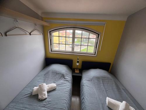 um pequeno quarto com 2 camas e uma janela em Sun House III - Near Sintra - Kitchen - Pool em Mem Martins