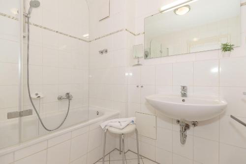 キュールングスボルンにあるStrandschloesschen-I-WE-10-9888の白いバスルーム(シンク、シャワー付)