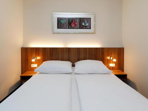 a bedroom with a large bed with two white pillows at B&B HOTEL Berlin-Mitte in Berlin