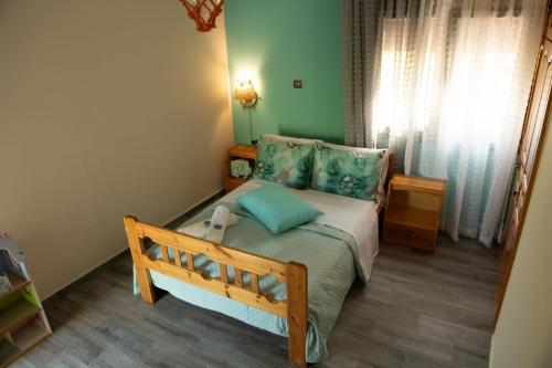 a small bedroom with a bed with blue pillows at Villa Olive and Sea in Mytilini