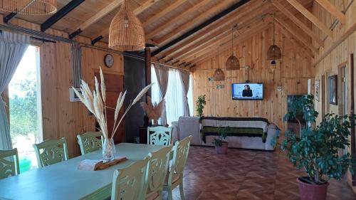 comedor con mesa y sofá en Casa Bosque Pichilemu, en Rinconada El Sauce