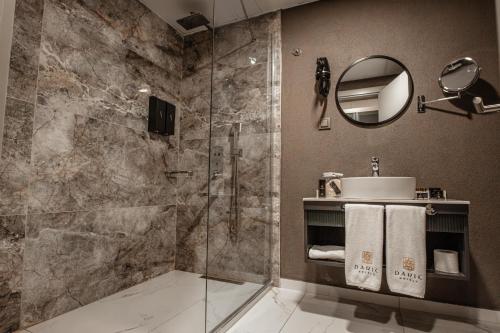 a bathroom with a shower and a sink and a mirror at DARIC HOTELS in Atakum