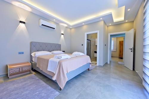 um quarto com uma cama grande e um corredor em MERA-12 FETHİYE KARGI HAVUZLU VİLLALARIMIZ em Fethiye