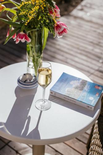 a table with a vase of flowers and a glass of wine at MelRose Relais in Massa Lubrense