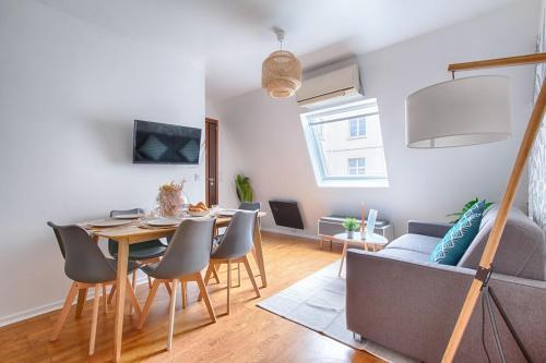 a dining room and living room with a table and chairs at Appartement near to Saint Lazare - 6P in Paris