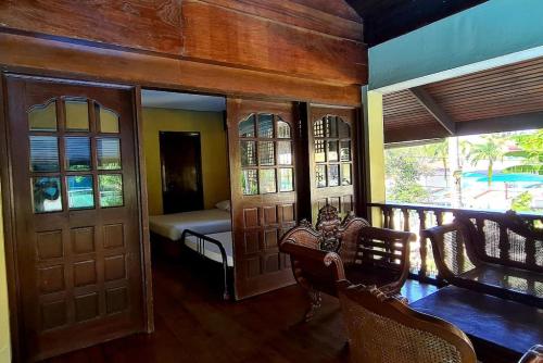 a room with a balcony with doors and a table and chairs at Spacious Spanish-Style Resort in Pansol Laguna in Calamba