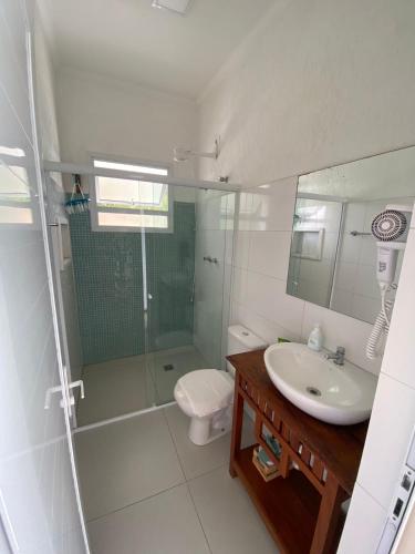 a bathroom with a glass shower and a sink at Residencial Águas de Bare in São Sebastião