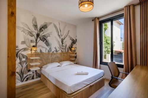 a bedroom with a bed with a plant mural on the wall at Sublime villa - centre Nice 8P in Nice